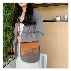 Detailed view of the stylish monogram crossbody bag with retro leather flap and metal buckle.