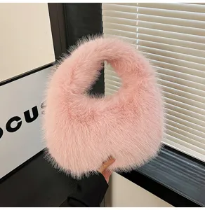 Dettaglio borsa a mano soffice rosa, primo piano di borsa dumpling in pelliccia sintetica invernale.