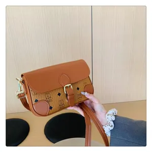 Detailed view of the stylish brown leather shoulder bag with monogram pattern and gold buckle.