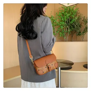 Detailed view of stylish brown crossbody shoulder bag with classic monogram pattern and flap.