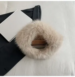 Primo piano di una borsa chic in pelliccia sintetica beige, ideale per dettagli autunnali e invernali.