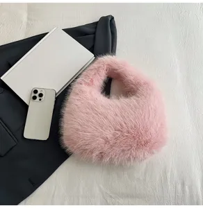 Primo piano dettagliato della soffice borsa in peluche rosa su tessuto bianco.