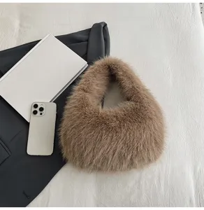 Dettaglio borsa a mano in peluche marrone, morbida borsa a sacco in ecopelliccia autunno inverno.