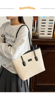 Detail shot of beige embossed tote bag with black handles, showcasing daily commute style.