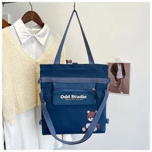 Blaue Canvas-Mehrzwecktasche mit Bärenmuster und Buchstaben für den täglichen Gebrauch.