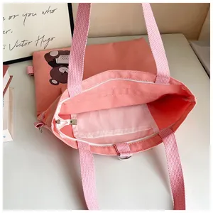 Rosa Segeltuchtasche mit niedlichem Bärenmotiv, vielseitigen Trägern und großem Fassungsvermögen.