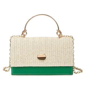 Vue détaillée du sac carré miniature en paille tissée et cuir vert avec poignée et chaîne en métal.