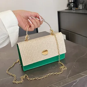 Sac à main chic en paille tressée avec bordure en cuir vert et bandoulière chaîne dorée.