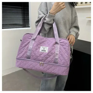 Detailed view of the large capacity quilted travel duffel bag in light purple with handles.