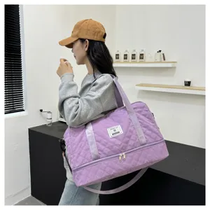 Detailed view of the purple quilted travel bag with a separate bottom compartment for fitness.