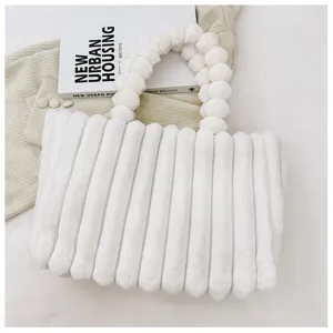 Detailed view of the fluffy white plush tote bag with beaded handle, soft texture design.