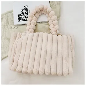Beige plush tote bag detail shot showing soft faux fur fabric and unique beaded handle.
