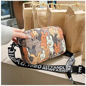 Cute cartoon rabbit pattern crossbody bag for women, stylish fabric shoulder bag with strap.