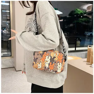 Detailed view of the cute cartoon rabbit print crossbody bag worn with a casual grey sweatshirt.