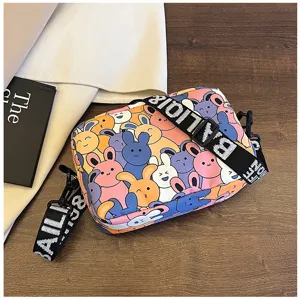 Details of the cute cartoon printed crossbody bag with stylish patterned strap on wood.