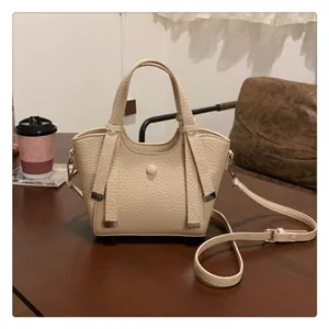 Beige leather crossbody shoulder bag detail, stylish commuter tote with adjustable strap.