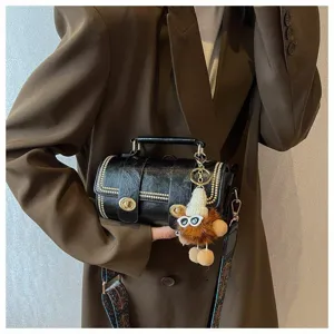 Details der retro schwarzen Zylindertasche mit Metallschloss und tollem Plüsch-Anhänger.
