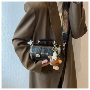 Retro Zylinder Umhängetasche für Damen mit schickem breitem Gurt und niedlichem Plüschanhänger.