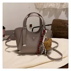 Stylish gray leather tote bag with shoulder strap and cute bear charm for daily commute.