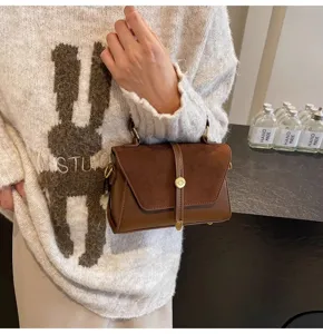 Braune Wildleder Patchwork Handtasche Detail mit Metallschloss und elegantem Umhängegurt.