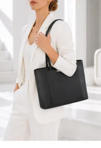 Detailed view of black leather tote bag, elegant shoulder carry in modern interior scene.