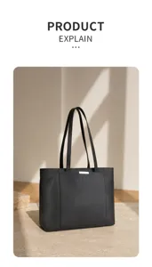 Detail view of black leather tote bag, showing premium pebble texture and elegant design.