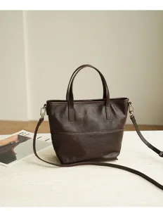 Brown leather tote bag detail, minimalist retro design with shoulder strap and handles.