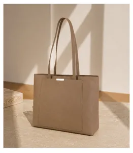 Minimalist genuine leather tote bag detail, spacious daily commute shoulder bag for women.