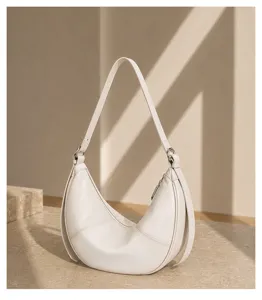 Minimalist genuine leather crescent shoulder bag detail shot, elegant soft hobo style.