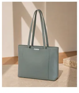 Close-up view of the grey-green leather tote bag showing double straps and metallic bar detail.