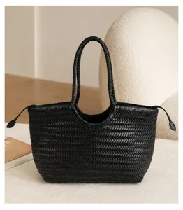Detailed view of black woven leather tote bag, chic braided handles and minimalist style.