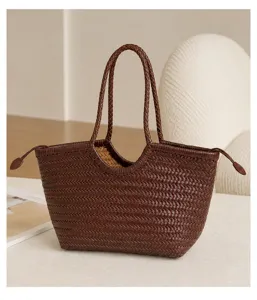 Close-up detail of the brown woven leather tote bag showing intricate craftsmanship and handle.