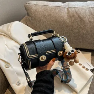 Schwarze Vintage Leder Zylinder Umhaengetasche mit Metallverschluesse und Pluesch Anhänger.