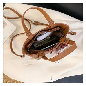 Detailed top-down view of brown leather tote bag interior, showing storage compartments.