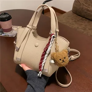 Beige textured leather tote bag for women, large capacity shoulder handbag with cute bear charm.