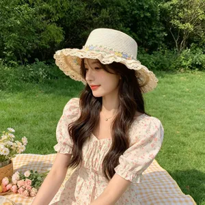 Outdoor straw sun hat scene detail, sweet lace floral embroidered wide brim sun protection hat.