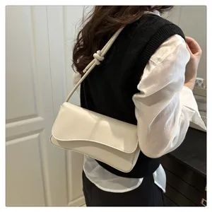 Detail view of a stylish white shoulder underarm bag featuring a chic knotted strap design.