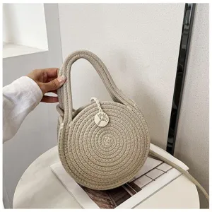 Detail view of woven round handbag showcasing texture, handle and natural style design.