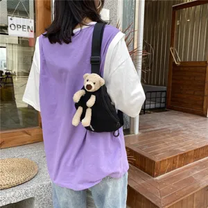 Detail shot of black canvas chest bag with cute plush bear, casual crossbody design.