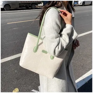 Close-up detail of women large capacity tote bag featuring embossed patterns and green handles.