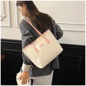 Detailed view of large capacity tote bag with embossed pattern and pink shoulder straps.