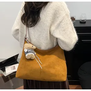 Brown suede hobo shoulder bag for women, large capacity retro slouchy tote with cute bear charm.