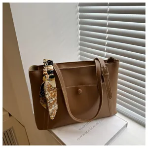 Classic brown leather tote bag for women, stylish shoulder bag with chic scarf decoration.