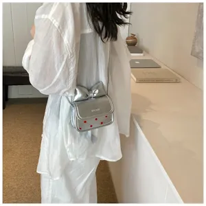 Silver metallic bow crossbody bag for women girls, cute shoulder purse with red dots.