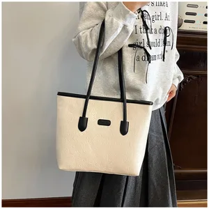 Detailed view of large PU leather tote bag with embossed cartoon patterns and black handles.