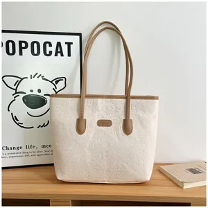 Casual large capacity embossed tote bag detail with brown straps and stylish pattern design.