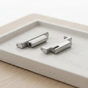 Close-up of metal watch strap adapter connectors in a minimalist textured tray, premium accessory.
