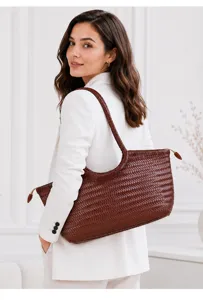 Detail shot of brown woven leather shoulder bag worn by model, showing texture and craftsmanship.