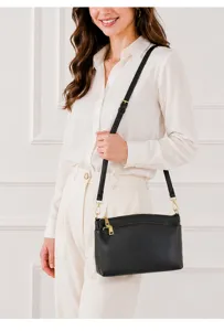 Detailed shot of the black leather crossbody bag worn by model, showing texture and hardware.