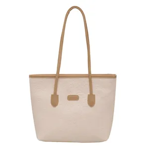 Beige large capacity tote bag for women, stylish embossed shoulder bag with brown straps.